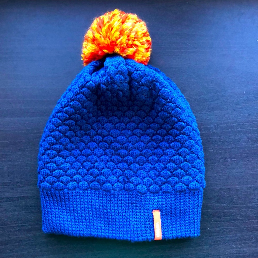 Blue knit hat with orange pom pom